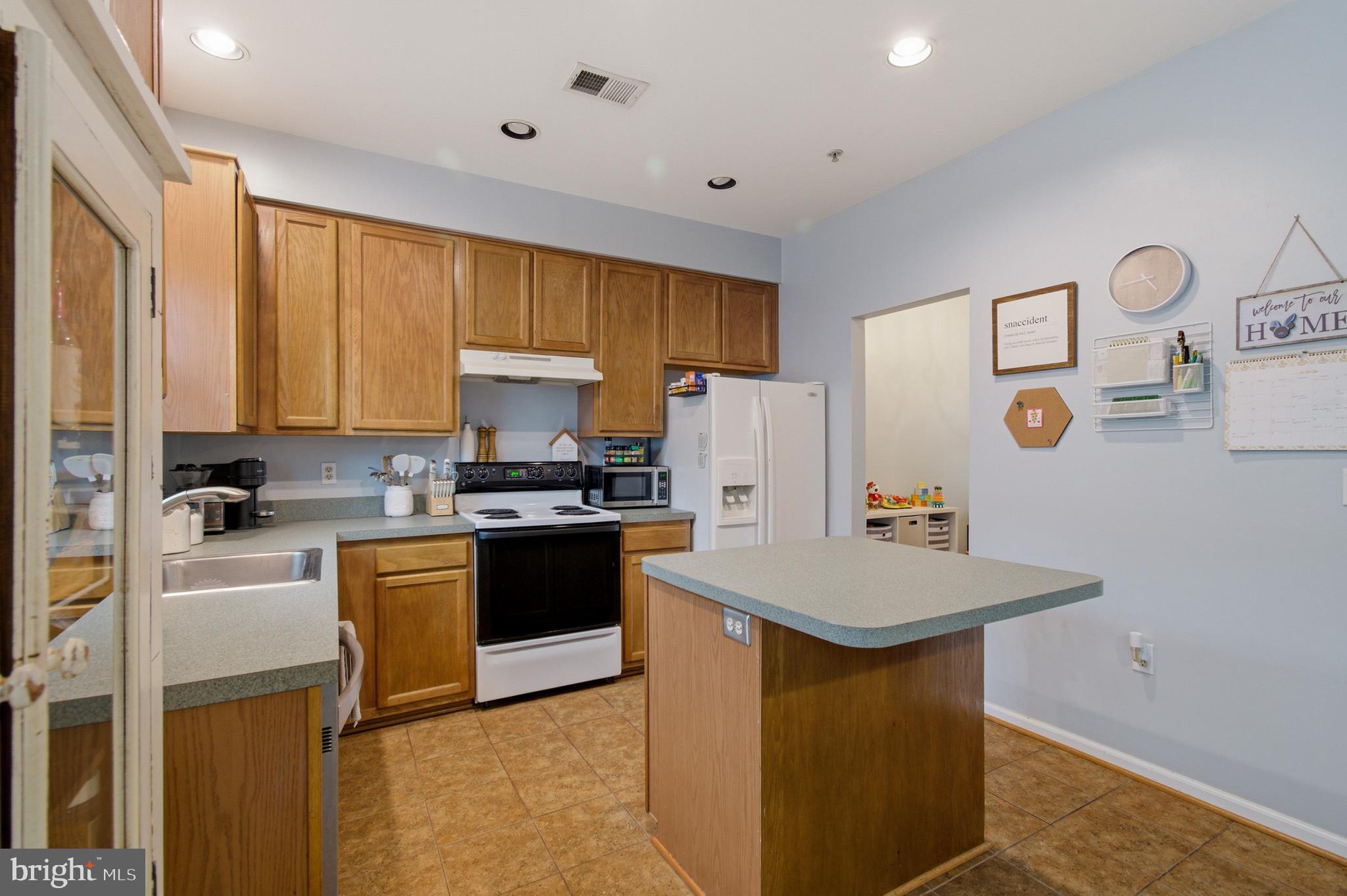 1212 Needham Court Crofton, MD 21114 - Photo 25 of 47 a kitchen with refrigerator cabinets and wooden floor