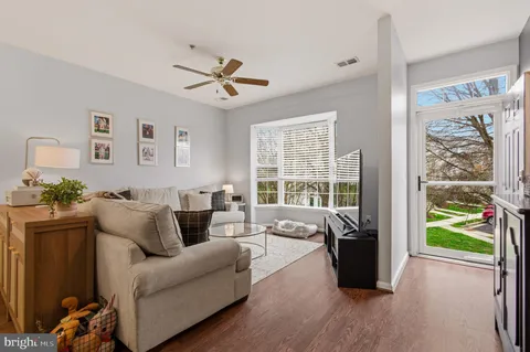 a living room with furniture a flat screen tv and a large window