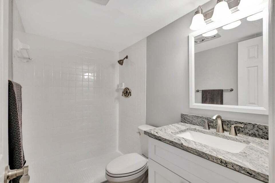 27 Camden B West Palm Beach, FL 33417 - Photo 15 of 34 a bathroom with a granite countertop sink a toilet and a mirror