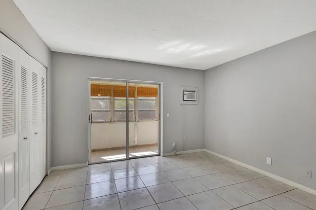 a view of an empty room with window and closet area