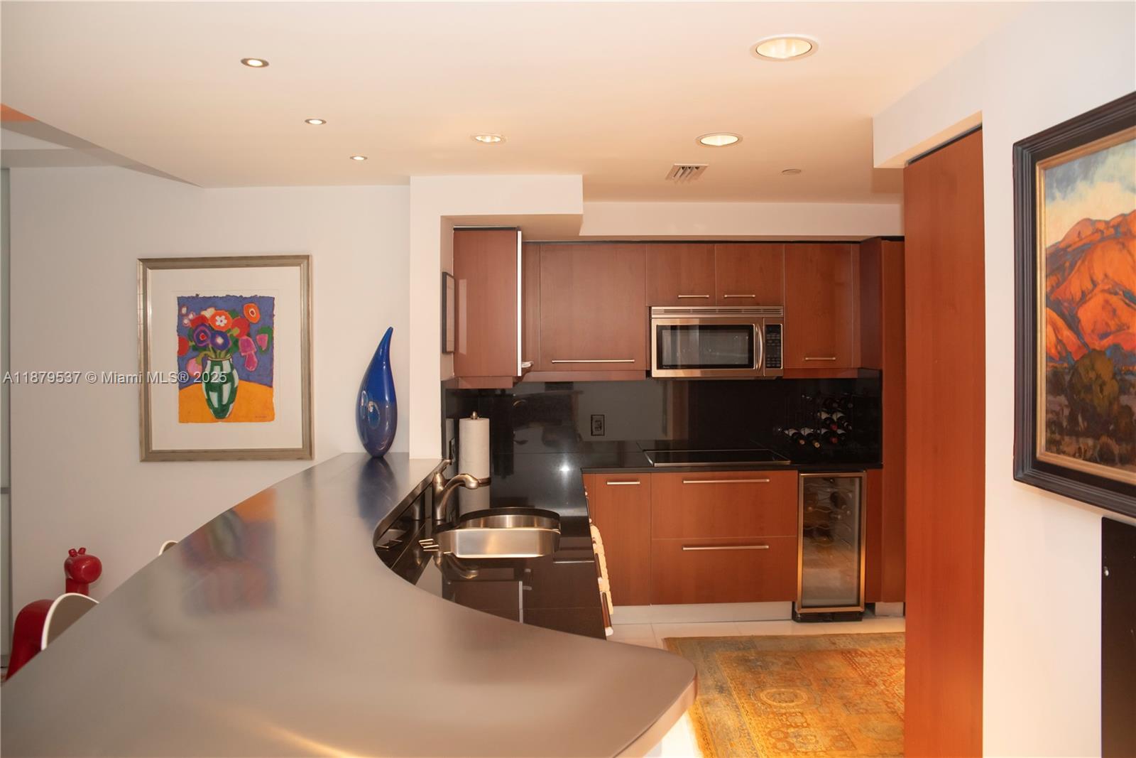 1331 Brickell Bay Drive, Unit 1505 Miami, FL 33131 - Photo 4 of 18 a kitchen with stainless steel appliances granite countertop a sink and a microwave