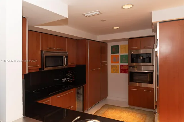 a kitchen with stainless steel appliances granite countertop a refrigerator and a stove top oven