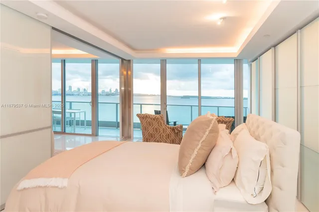 a bedroom with a bed and a large window