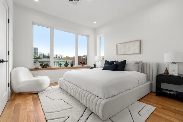 a bedroom with a bed and a large window