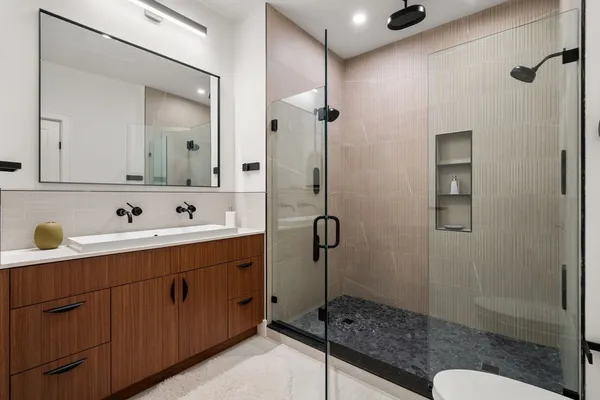 a bathroom with a shower sink and mirror