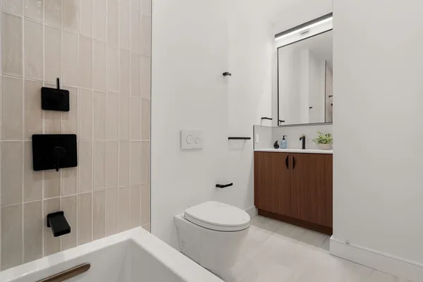 a bathroom with a toilet a sink and mirror