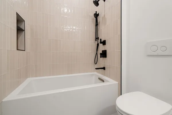 a white bath tub sitting next to a toilet