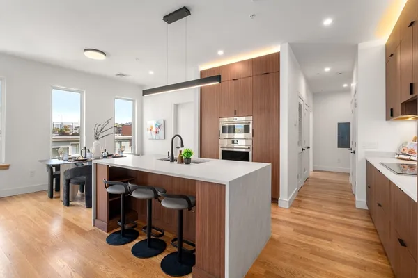 a kitchen with stainless steel appliances a dining table chairs and granite counter tops