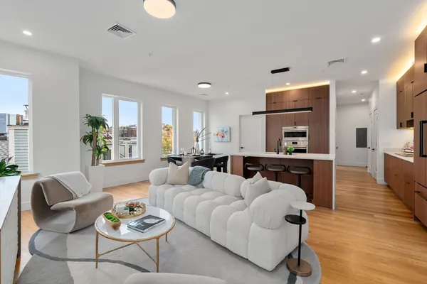 a living room with furniture kitchen and a wooden floor