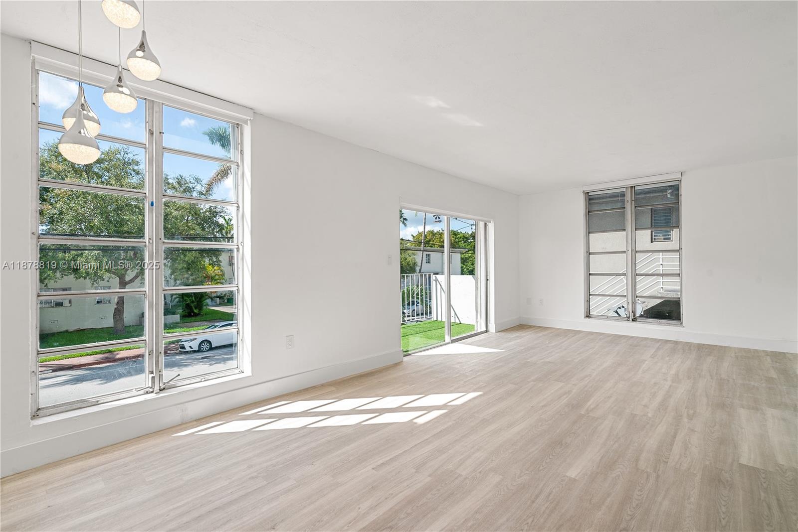 8305 Crespi Boulevard, Unit 2D Miami Beach, FL 33141 - Photo 1 of 33 a view of an empty room with wooden floor and a window
