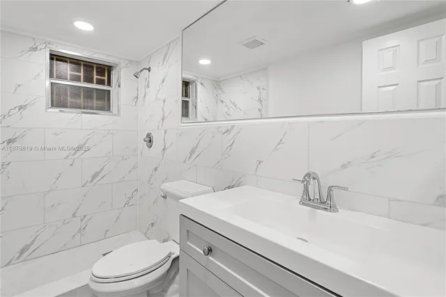 a bathroom with a sink a toilet and shower