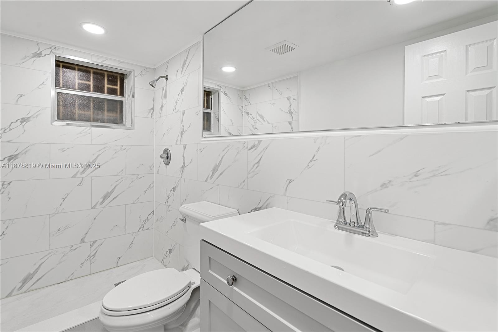 8305 Crespi Boulevard, Unit 2D Miami Beach, FL 33141 - Photo 11 of 33 a bathroom with a sink a toilet and shower