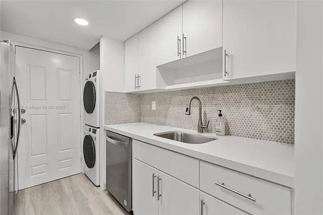 a kitchen with stainless steel appliances a sink a refrigerator and cabinets