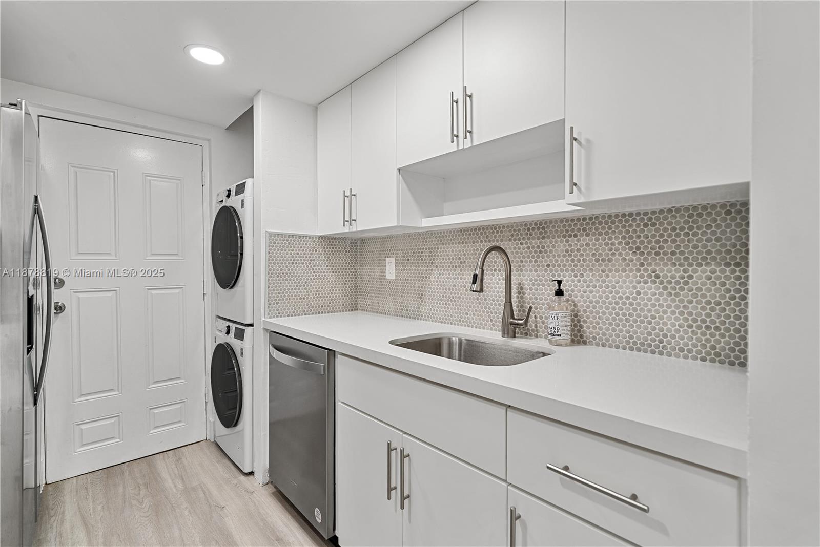 8305 Crespi Boulevard, Unit 2D Miami Beach, FL 33141 - Photo 5 of 33 a kitchen with stainless steel appliances a sink a refrigerator and cabinets