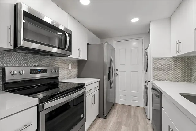 a kitchen with stainless steel appliances a stove microwave and cabinets