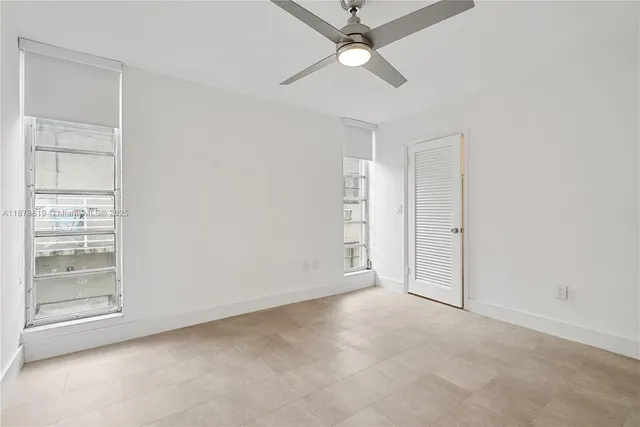 an empty room with closet and a ceiling fan