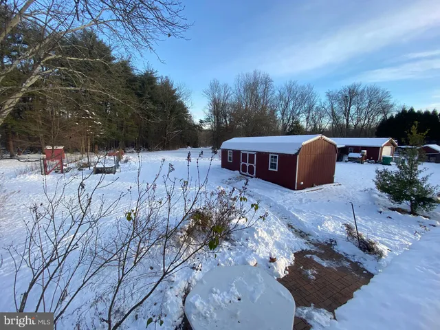 a view of a house with a yard covered with snow