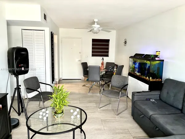 a living room with furniture a flat screen tv and a window