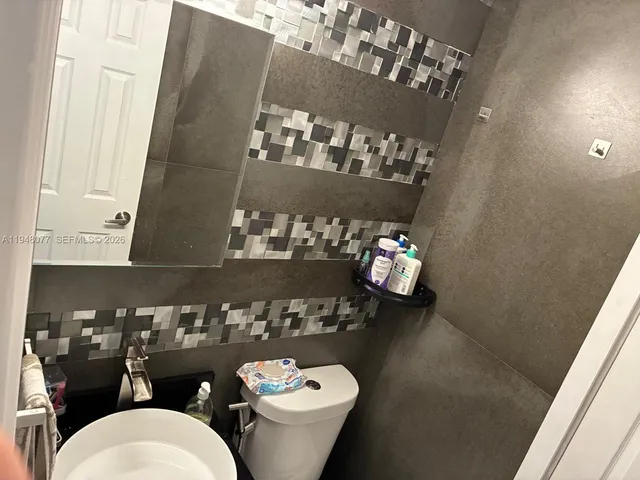 a bathroom with a toilet sink and mirror