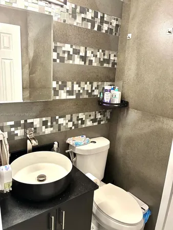 a bathroom with a toilet a sink and mirror