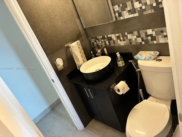 a bathroom with a toilet mirror vanity and a sink