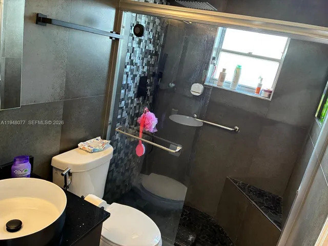a bathroom with a toilet a sink and a mirror
