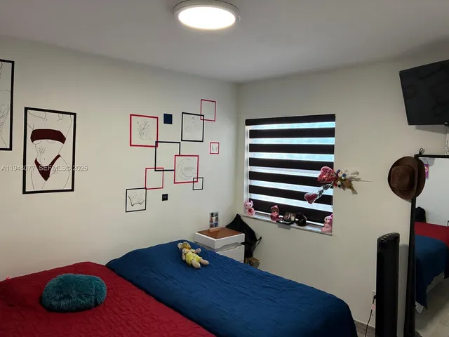 a bedroom with a bed and a laptop on the desk
