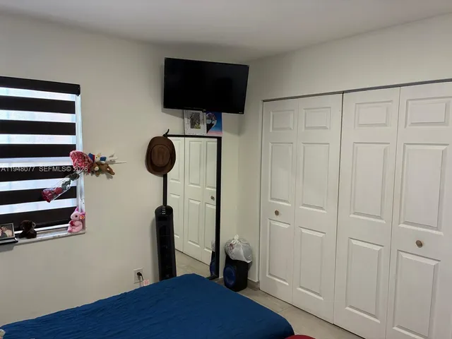 a bedroom with a bed and a flat screen tv