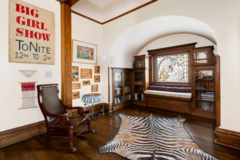 a bedroom with a large bed a chandelier and dresser
