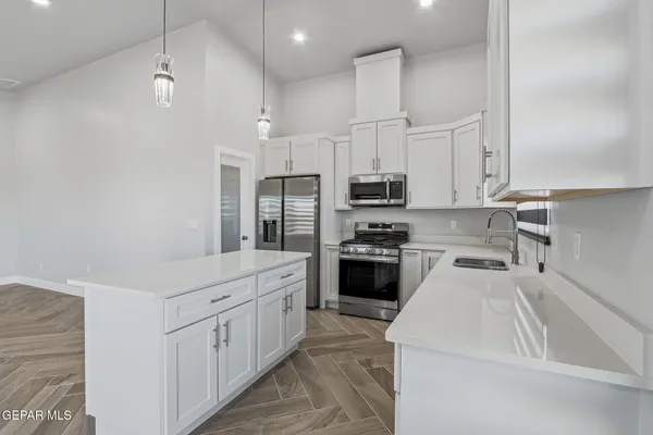 a kitchen with white cabinets and stainless steel appliances