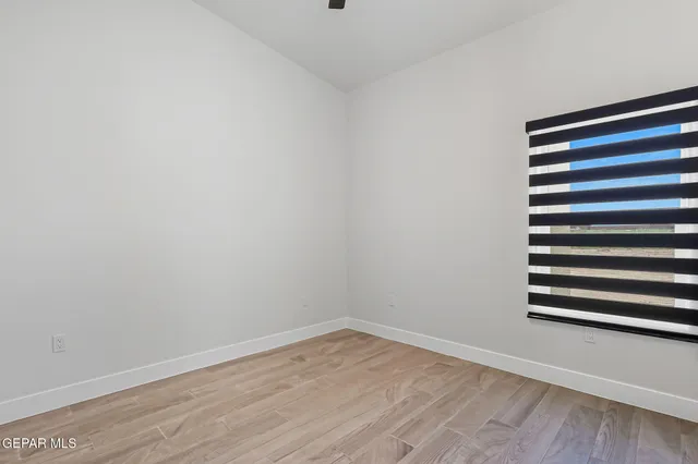 a view of a room with wooden floor and a window