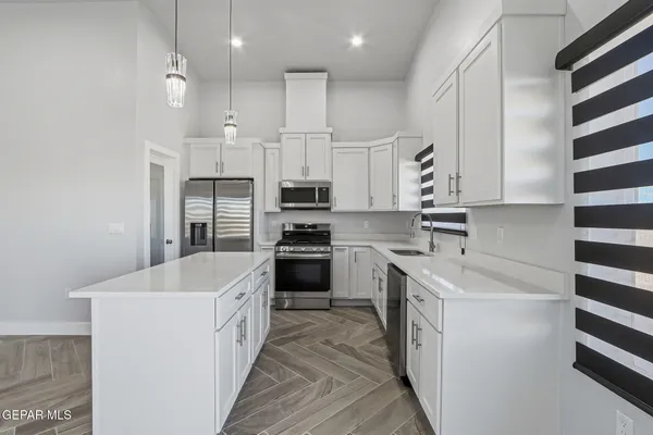 a kitchen with stainless steel appliances kitchen island granite countertop a sink and a stove top oven
