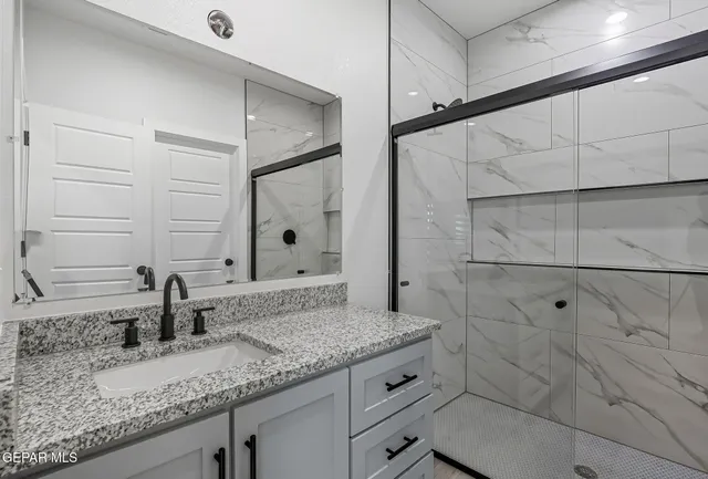 a bathroom with a granite countertop sink and a mirror