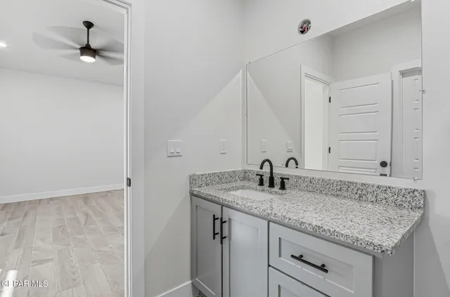 a bathroom with a granite countertop sink and a mirror