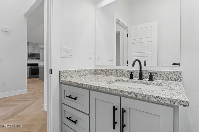 a bathroom with a granite countertop sink and a mirror