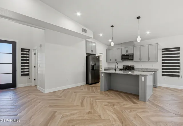 a kitchen with stainless steel appliances kitchen island granite countertop a refrigerator oven a sink with dishwasher and wooden cabinets