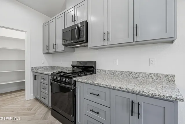 a kitchen with stainless steel appliances granite countertop white cabinets sink and dishwasher