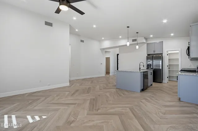 a view of a kitchen with refrigerator and wooden floor