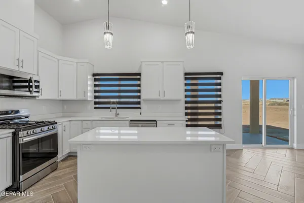 a kitchen with granite countertop a sink a stove and cabinets