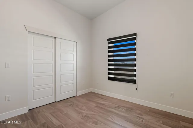 a view of a room with a wooden floor and entryway