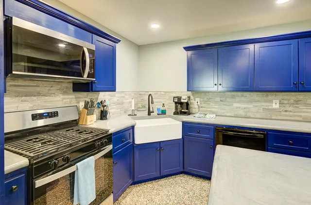 a living room with large couches and kitchen view with wooden floor