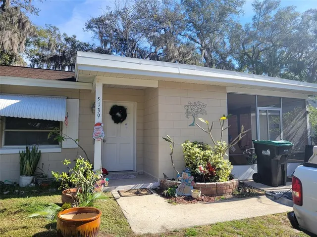a front view of a house with lots of flowers planted