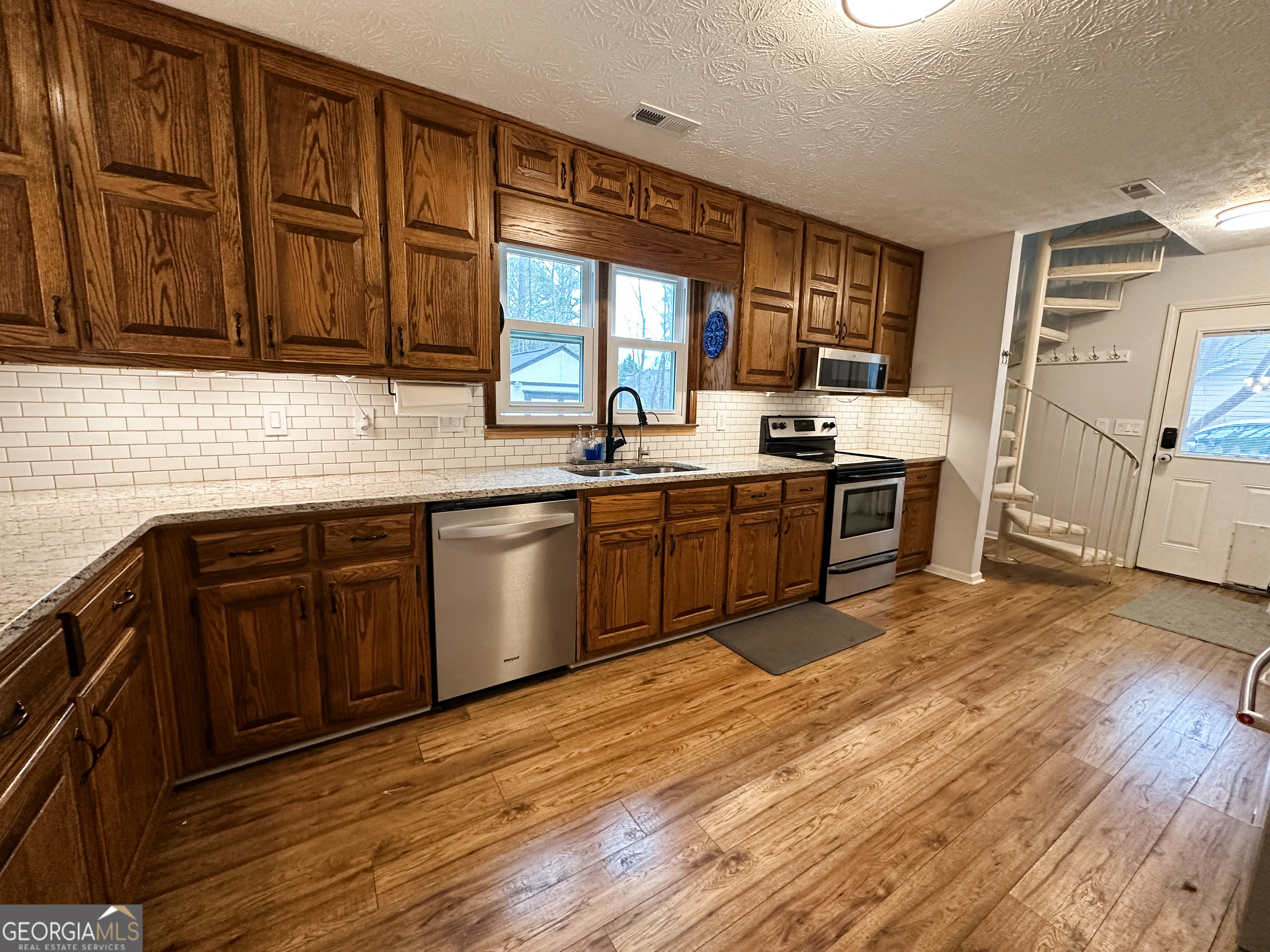 502 Richey Place Peachtree City, GA 30269 - Photo 11 of 61 a kitchen with stainless steel appliances granite countertop a sink stove and wooden cabinets