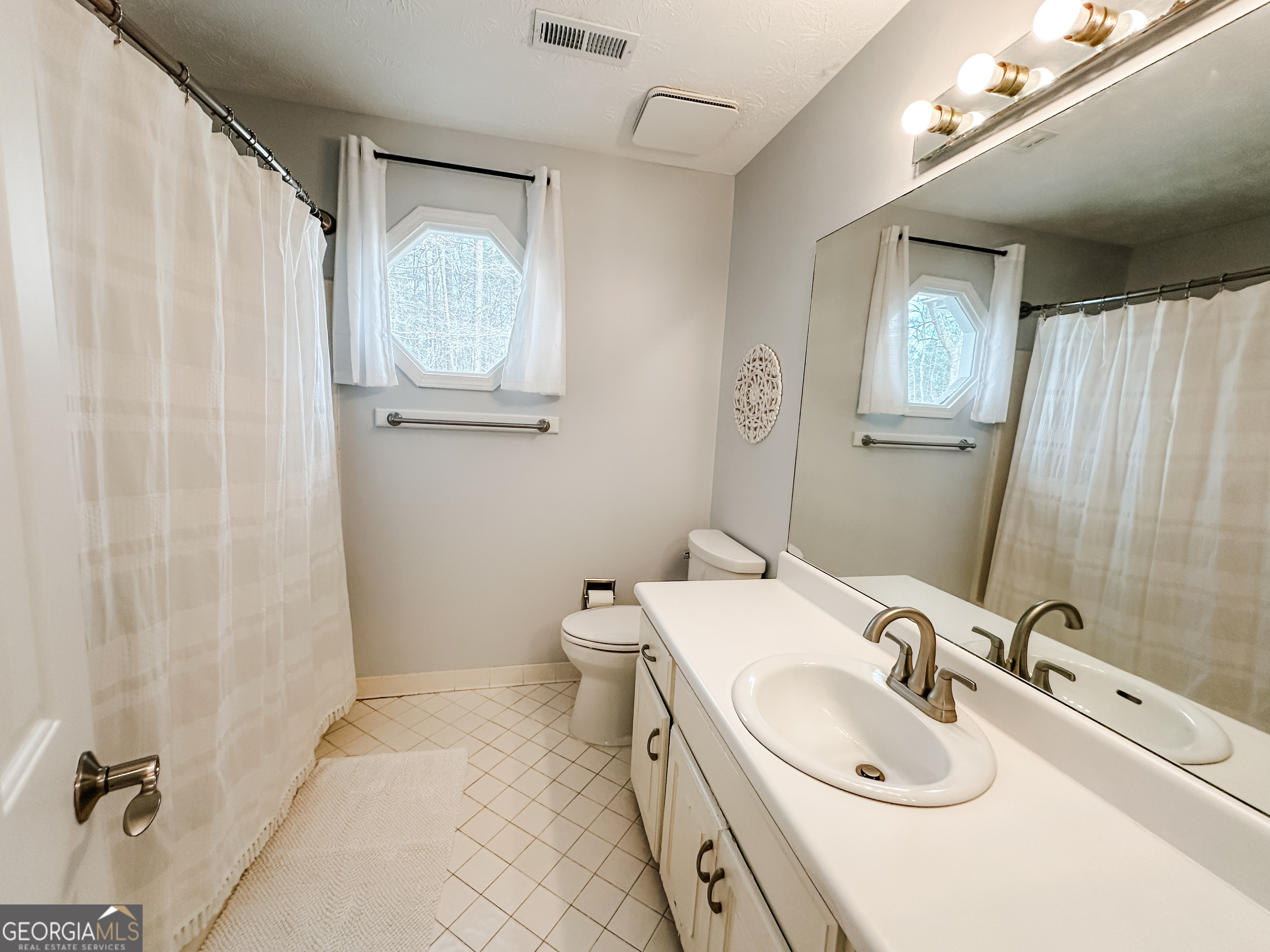 502 Richey Place Peachtree City, GA 30269 - Photo 48 of 61 a bathroom with a sink a toilet and mirror