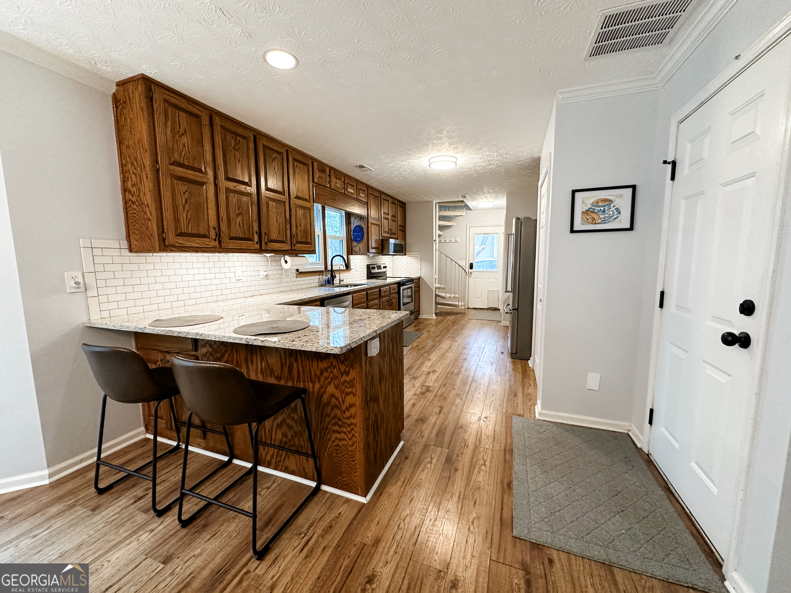 502 Richey Place Peachtree City, GA 30269 - Photo 7 of 61 a kitchen with granite countertop a table chairs stove and cabinets