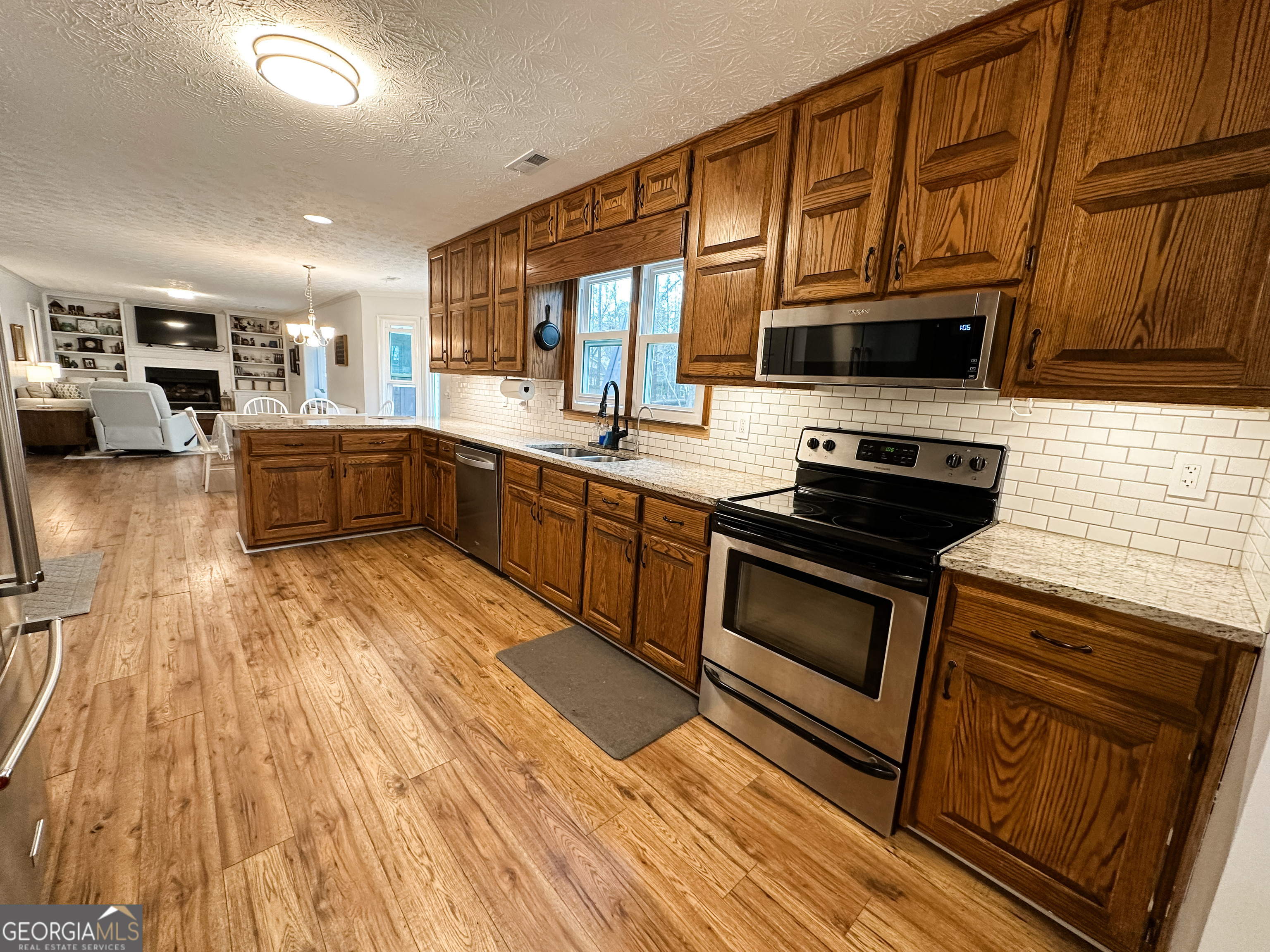 502 Richey Place Peachtree City, GA 30269 - Photo 9 of 61 a kitchen with stainless steel appliances wooden cabinets and a stove top oven