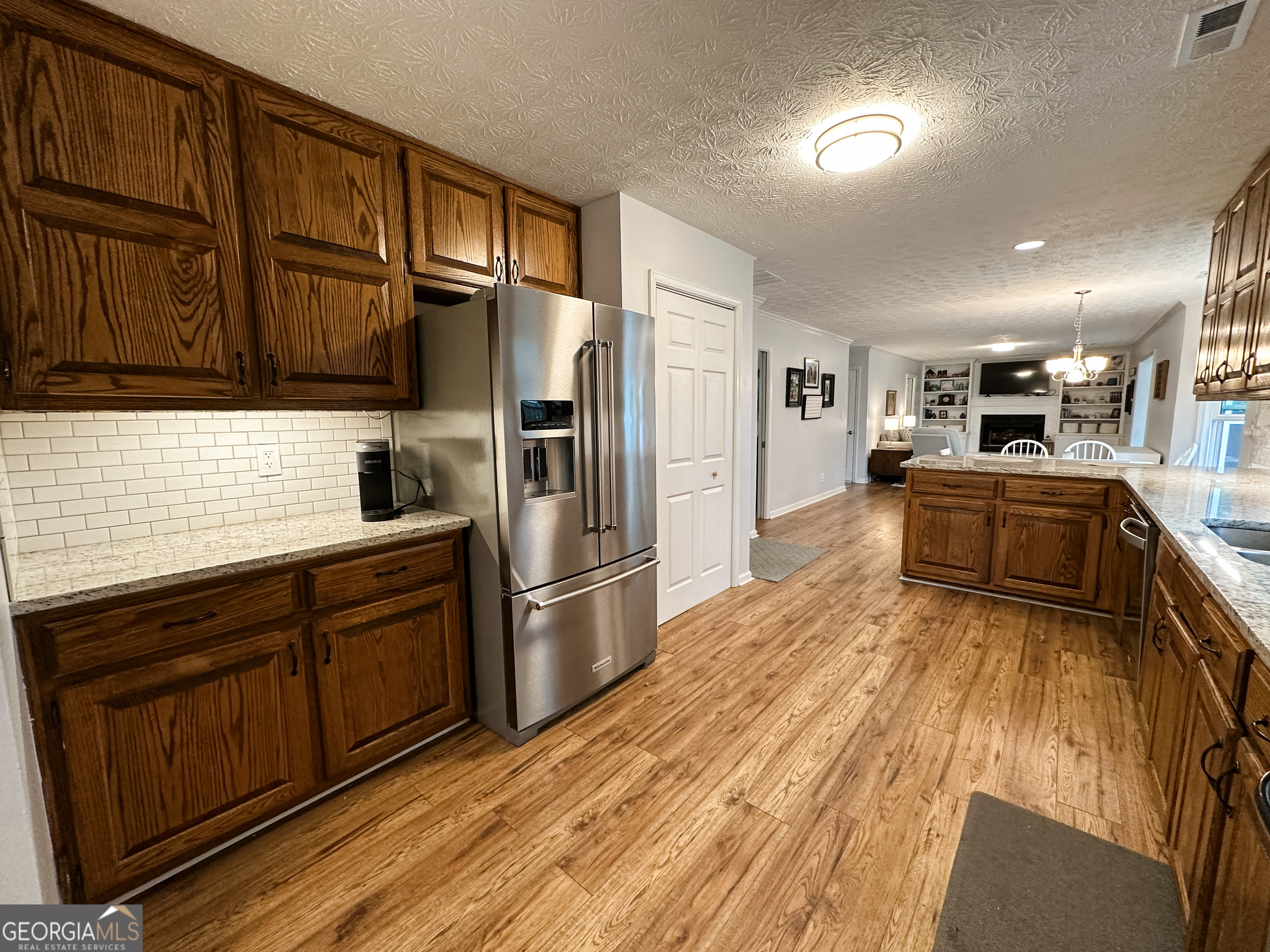 502 Richey Place Peachtree City, GA 30269 - Photo 10 of 61 a kitchen with granite countertop wooden cabinets a refrigerator and stainless steel appliances