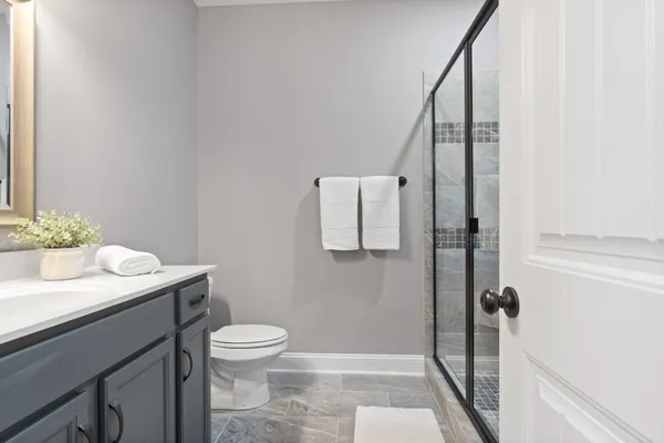 a bathroom with a granite countertop sink toilet and shower