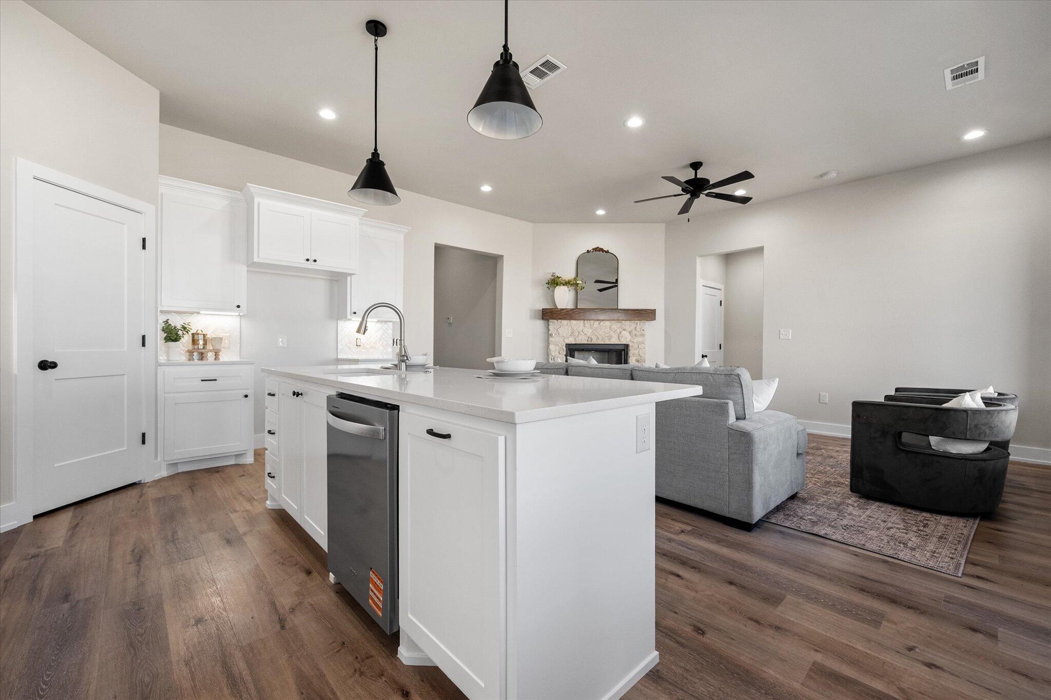 1404 Durham Avenue Wolfforth, TX 79382 - Photo 13 of 34 a kitchen with kitchen island granite countertop a sink cabinets and wooden floor