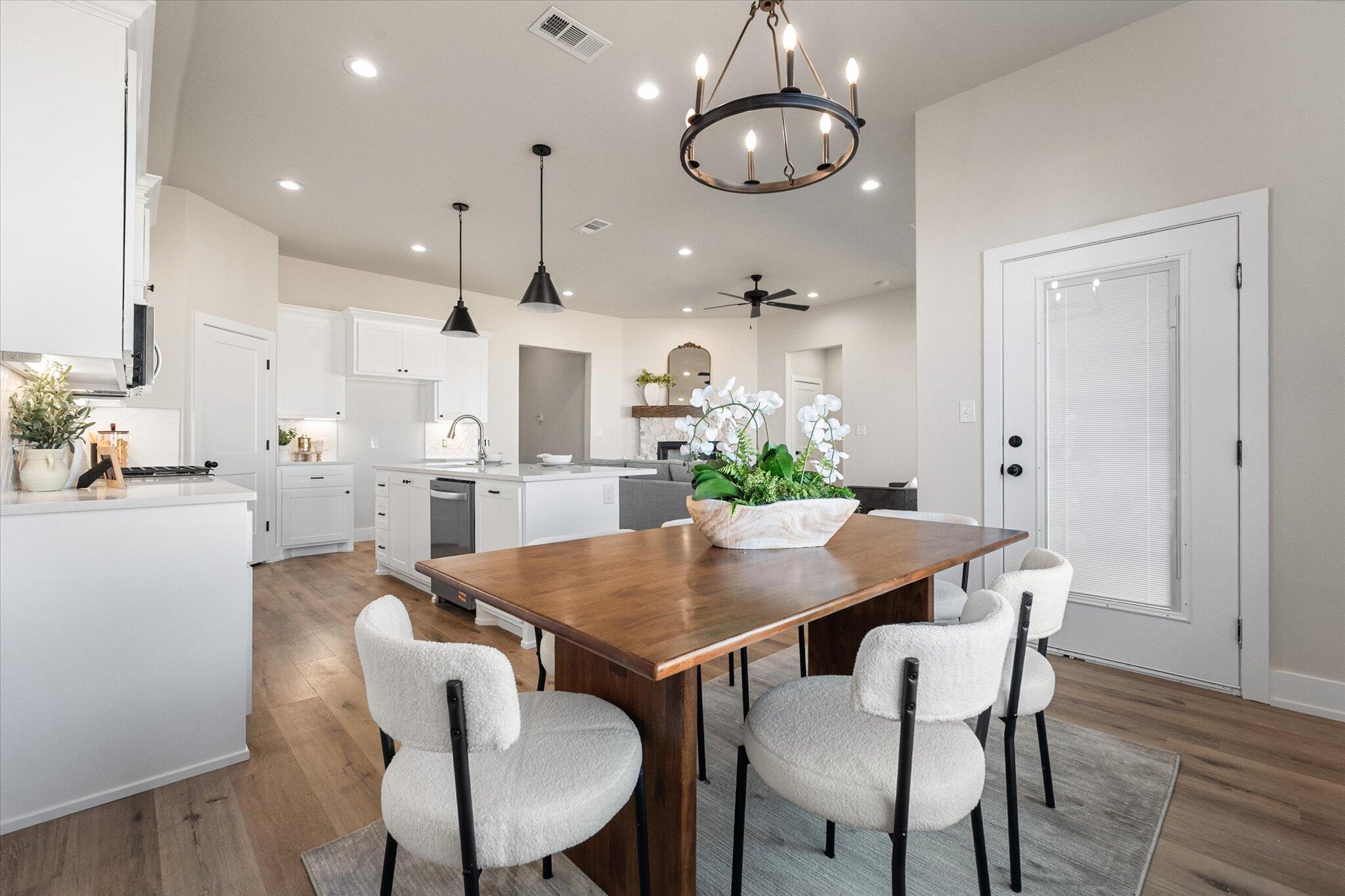1404 Durham Avenue Wolfforth, TX 79382 - Photo 16 of 34 a view of a dining room with furniture a chandelier and wooden floor